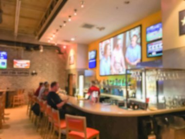 Spor bar ve restoran ABD'de tezgahta Bar bulanık. Büyük duvara monte düz ekran Tv, klasik ahşap masa, sandalye. İnsanlar tekne dışarı asılı, spor izlerken bira içmek