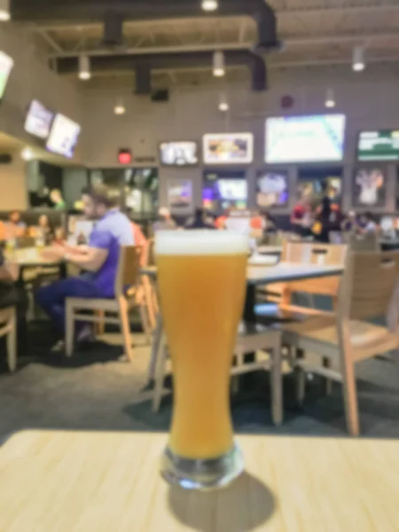 Blurred abstract fresh wheat beer in weizen glasses at  casual dining restaurant and sports bar in America