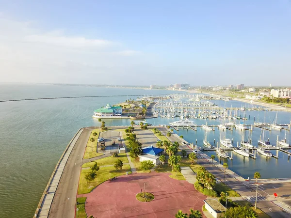 Aerial view sailboat is moored at the quay, yacht parking in Corpus Christi bay front area. Top pier speedboat in marina lot filled full row of boat. Travel and recreation background
