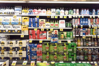 FORT WORTH, TX, USA-SEP 3, 2017:Wide selection of domestic and imported beer at Fiesta Latino-American supermarket chain. Various bottles and cans of Mexican and international beers Corona, Heineken clipart