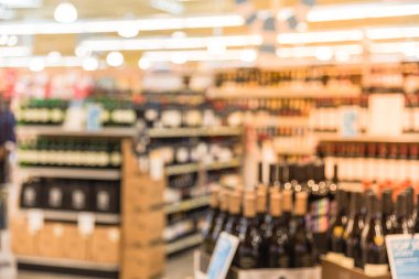 Houston, Texas, mağazada sergilenen fiyat etiketleri ile şarap raflar bulanık görüntü bize. Ufuk satır şarap likör şişeleri süpermarket rafta. Alkollü içecek arka plan.