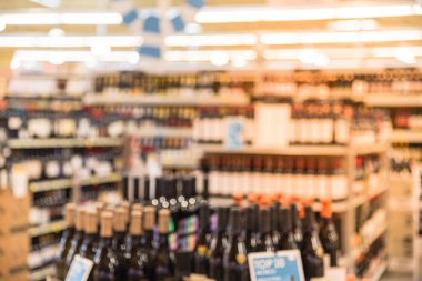 Houston, Texas, mağazada sergilenen fiyat etiketleri ile şarap raflar bulanık görüntü bize. Ufuk satır şarap likör şişeleri süpermarket rafta. Alkollü içecek arka plan.