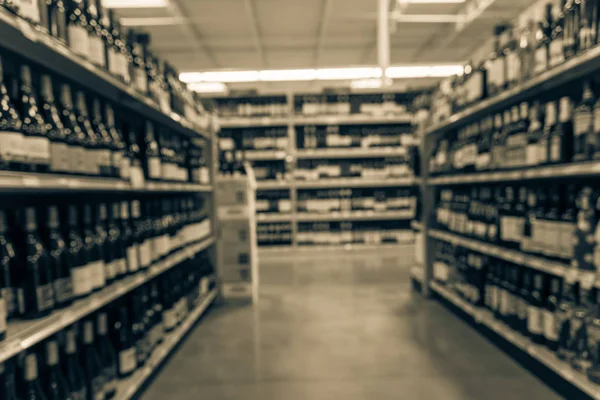 Vintage tone blurred wine shelves with price tags on display at store in Houston, Texas, US. Defocused rows of Wine Liquor bottles on the supermarket shelf. Alcoholic beverage abstract background