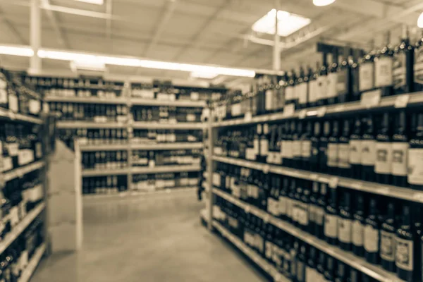 Vintage tone blurred wine shelves with price tags on display at store in Houston, Texas, US. Defocused rows of Wine Liquor bottles on the supermarket shelf. Alcoholic beverage abstract background