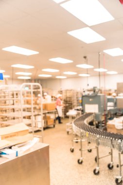 Hareket bitki soğutma işçi pişirme makinesi, fırın, konveyör, üretim hattı, mikser, ile toptan mağaza fırın dükkânında üniformalı bulanık. Modern gıda işleme tesisi fabrika. Endüstri kavramı