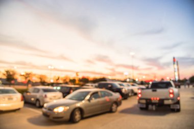 Humble, Texas, modern alışveriş merkezinin dış görünümü bize günbatımında bulanık. Karmaşık satır araba açık açık otoparklar, bokeh arka planda ışık direkleri ve perakende mağaza ile alışveriş merkezi.