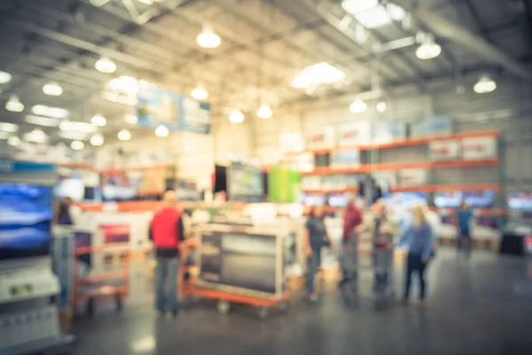 Vintage tone blurred TVs shopping large wholesale club. Television retail shop, row of big screen, smart TV display. Store staff help customers select and use flatbed cart carry TV to checkout counter