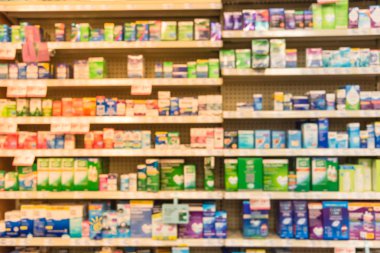 Eczane deposu ile ilaç ve tıbbi sarf malzemeleri ürün rafları ekranda etiketindeki görücü usulü varyasyonu içinde arka plan bulanık. İlaç deposu bulanık ilaçlar ile kapalı alanı.