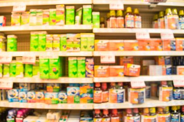 Eczane deposu ile ilaç ve tıbbi sarf malzemeleri ürün rafları ekranda etiketindeki görücü usulü varyasyonu içinde arka plan bulanık. İlaç deposu bulanık ilaçlar ile kapalı alanı.