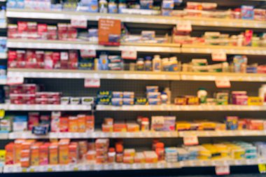 Eczane deposu ile ilaç ve tıbbi sarf malzemeleri ürün rafları ekranda etiketindeki görücü usulü varyasyonu içinde arka plan bulanık. İlaç deposu bulanık ilaçlar ile kapalı alanı.