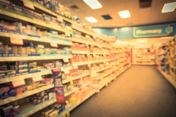 Blurred abstract background inside pharmacy store with arranged variation of pharmaceutical and medical supplies product in label on shelves display. Indoor space of drug store with blurred medicines.