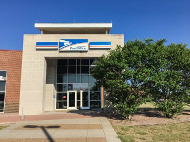 IRVING, TX, USA-SEP 2, 2018:Entrance exttorior of USPS store sunny summer clear blue sky. The United States Postal Service is an independent agency of US federal government providing postal service clipart
