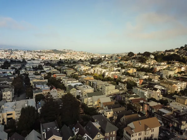 Aerial view Eureka Valley neighborhood with rolling hills cityscape, typical Victorian houses. Castro District is synonymous with gay culture, tightly packed residential homes under summer foggy