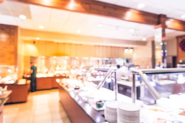 Abstract blurred Japanese buffet restaurant sushi bar counter interior with customers choosing sushi, sashimi and chef prepares to serve food. Food buffet catering dining eating party sharing concept.