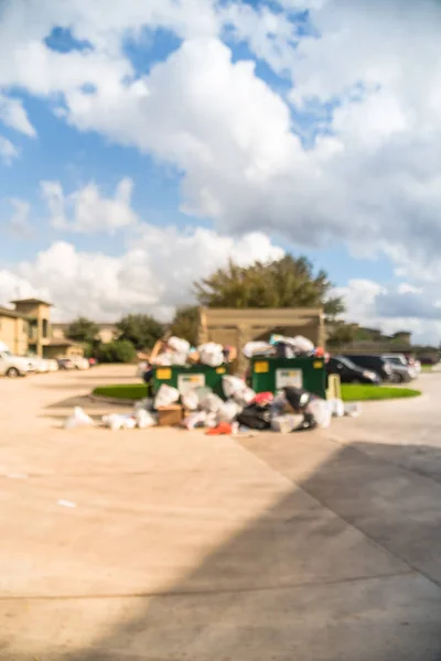 模糊了一个溢出垃圾桶在公寓楼院子里 在卑微 得克萨斯州 溢出和地上满是家居垃圾 塑料袋 节假日后的箱子 城市垃圾管理 — 图库照片