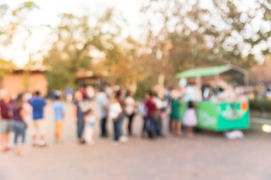 Bulanık bir dondurma vagonu satıcıda Houston, Texas, Şehir Parkı önünde queuing uzun insanlar bize. Ufuk yöre halkı ve turistlerin soğuk içecekler ve taze meyve suyu satın almak için bekliyor. Yan görünüm.