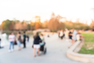 Houston, Texas, gün batımında şehir park lake yakınındaki açık hava etkinlikleri bulanık bize. Yürüyüş, Bebek arabası ile jogging veya göle doğru merdivenlerde temiz hava zevk insanlar. Ufuk arka plan kalabalık insanlar
