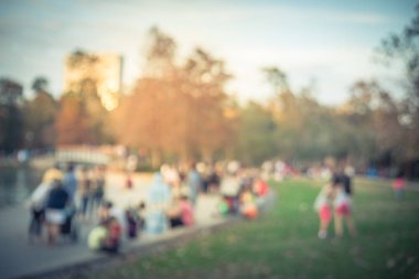 Bulanık görüntü çocuklar çim çim ve oturma ve Houston, Texas, gölde doğru merdivenlerde temiz hava zevk insanlar üzerinde çalışan bize. Ufuk açık Aile aktiviteleri lake city Park yakınındaki gün batımında