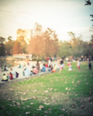 Bulanık görüntü çocuklar çim çim ve oturma ve Houston, Texas, gölde doğru merdivenlerde temiz hava zevk insanlar üzerinde çalışan bize. Ufuk açık Aile aktiviteleri lake city Park yakınındaki gün batımında