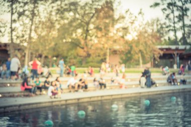 Bulanık oturan ve Houston, Texas, gölde doğru merdivenlerde temiz hava zevk görüntü insanlar bize. Ufuk arka plan açık hava etkinlikleri kalabalık insan Şehir Parkı gölde gün batımında yakınındaki..