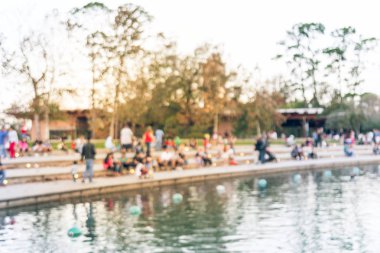 Bulanık oturan ve Houston, Texas, gölde doğru merdivenlerde temiz hava zevk görüntü insanlar bize. Ufuk arka plan açık hava etkinlikleri kalabalık insan Şehir Parkı gölde gün batımında yakınındaki..