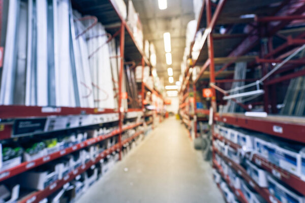 Vintage tone blurred a large hardware store in America. Defocused interior home improvement retailer with rack of fence, gate, poultry mesh and gutter hardware and building material, floor up ceiling