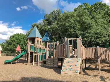 Genel ahşap Çocuk Bahçesi gür Coppell, Texas, ABD büyük ağaçların altında yapısı ve maymun barda tırmanmak. Yaprakları yaz yeşil tarafından çevrili küme açık oyuncaklar oynamak ve mavi gökyüzü bulut