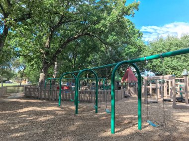 Kemer salıncak gür Coppell, Texas, ABD büyük ağaçların altında genel ahşap çocuk oyun alanı olarak belirlenmiştir. Küme yapısı yaprakları yaz yeşil tarafından çevrili oynamak ve mavi gökyüzü bulut