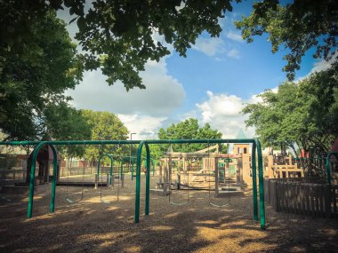 Kemer salıncak gür Coppell, Texas, ABD büyük ağaçların altında genel ahşap çocuk oyun alanı olarak belirlenmiştir. Küme yapısı yaprakları yaz yeşil tarafından çevrili oynamak ve mavi gökyüzü bulut