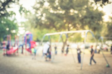Vintage bokeh çocuklar bize meşgul genel Bahçesi, salıncak üzerinde bulanık. Ufuk çocuklar, ebeveynler birlikte aktivite yapıyor. Koltuk ileri geri dan askıya asılı. Arka planda renkli Bahçesi