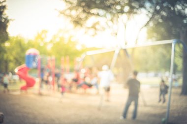 Vintage bokeh çocuklar bize meşgul genel Bahçesi, salıncak üzerinde bulanık. Ufuk çocuklar, ebeveynler birlikte aktivite yapıyor. Koltuk ileri geri dan askıya asılı. Arka planda renkli Bahçesi