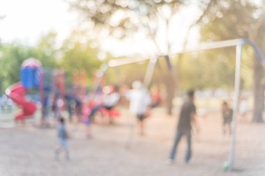 Bokeh çocuklar meşgul genel Bahçesi ABD, salıncak üzerinde bulanık. Ufuk çocuklar, ebeveynler birlikte aktivite yapıyor. Koltuk ileri geri dan askıya asılı. Arka planda renkli Bahçesi