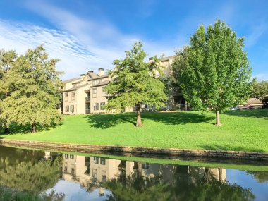 Irving, Texas, ABD Olgun ağaçlar çevrili tipik multistorey nehir kenarında daire konut kompleksi ayna yansıması.