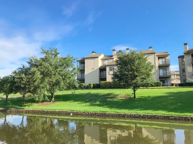Irving, Texas, ABD Olgun ağaçlar çevrili tipik multistorey nehir kenarında daire konut kompleksi ayna yansıması.