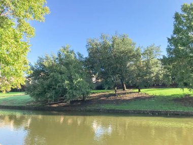 Irving, Texas, ABD Olgun ağaçlar çevrili tipik nehir kıyısındaki evlerin ayna yansıması.