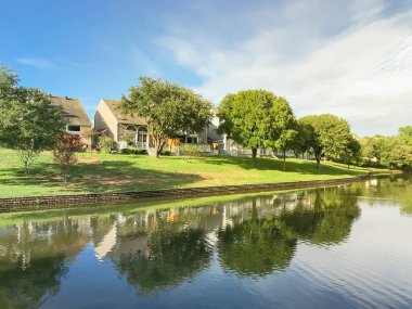 Irving, Texas, ABD Olgun ağaçlar çevrili tipik nehir kıyısındaki evlerin ayna yansıması.