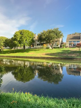 Irving, Texas, ABD Olgun ağaçlar çevrili tipik nehir kıyısındaki evlerin ayna yansıması.