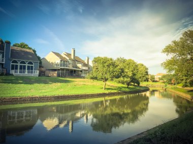 Irving, Texas, ABD Olgun ağaçlar çevrili tipik nehir kıyısındaki evlerin ayna yansıması.