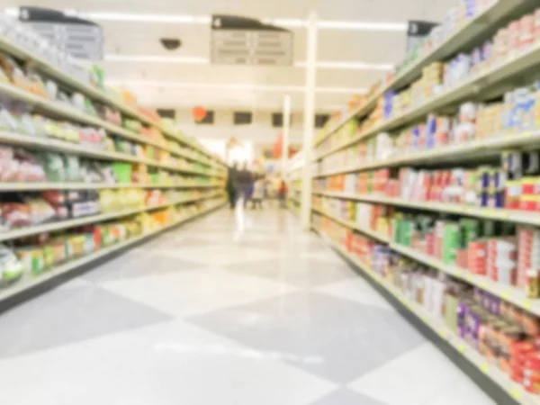 Motion blurred customer shopping for coffee, tea, herbal remedies and canned food aisle at Asian store in Dallas, Texas, US. Wide defocused view of supermarket shelves, variety of products on display
