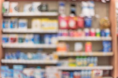 Eczane deposu ile ilaç ve tıbbi sarf malzemeleri ürün rafları ekranda etiketindeki görücü usulü varyasyonu içinde arka plan bulanık. Bulanık ilaçlar ile kapalı ilaç deposu. Panorama