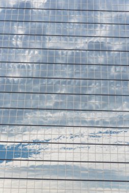 Yakın çekim ayrıntı modern iş Amerika'da kurma cam duvar bulut yansıması bir kadeh. Yüksek katlı ticari gökdelenin, şehrin gelecekteki kavramının çelik açık mavi renkli