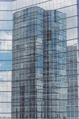 Bulutlar ve ayna bina modern ofis çalışma alanı Windows'da yansıtıyordu. Çelik açık mavi renkli cam yüksek katlı ticari gökdelenin, şehrin gelecekteki kavramının