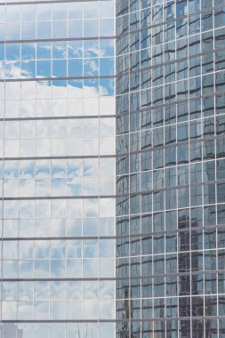 Bulutlar ve ayna bina modern ofis çalışma alanı Windows'da yansıtıyordu. Çelik açık mavi renkli cam yüksek katlı ticari gökdelenin, şehrin gelecekteki kavramının