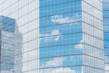 Bulutlar ve ayna bina modern ofis çalışma alanı Windows'da yansıtıyordu. Çelik açık mavi renkli cam yüksek katlı ticari gökdelenin, şehrin gelecekteki kavramının