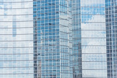Bulutlar ve ayna bina modern ofis çalışma alanı Windows'da yansıtıyordu. Çelik açık mavi renkli cam yüksek katlı ticari gökdelenin, şehrin gelecekteki kavramının