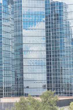 Tipik cam cephe ağaç üst arka plan, mavi bulut gökyüzü ile bina modern ayna cam duvara yansıyan