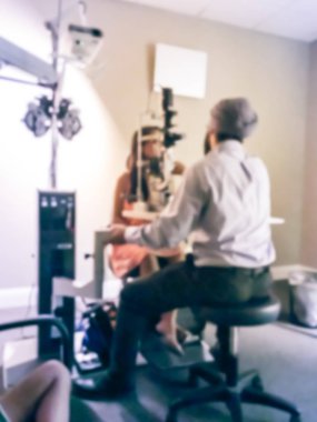 Vintage sesi hareket Asya hanımefendi hasta kadın göz hastalıkları kliniğinde tıbbi malzeme kullanarak bir göz doktoru tarafından muayene gözlerini yaptırıyor bulanık