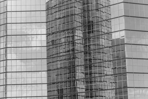 Vintage tone clouds and mirror building reflected in windows of modern office workspace. Steel light blue background of glass high-rise commercial skyscraper, the city of future concept