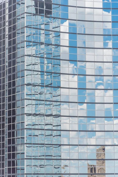 Close-up detail shot of cloud reflection on glass wall of modern business building in America. Steel light blue background of high-rise commercial skyscraper, the city of future concept