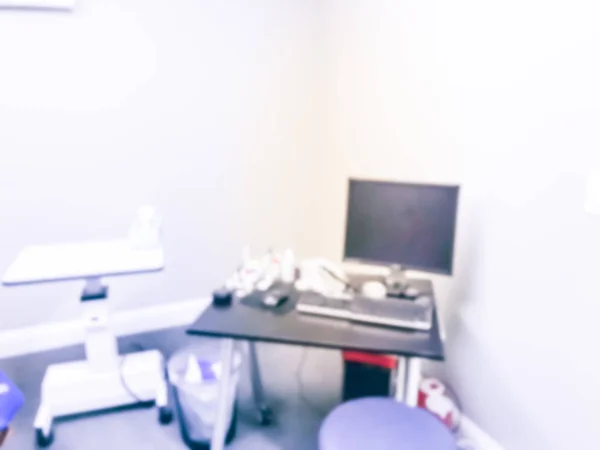 Abstract blurred computer and eye drops on table of eye and laser specialists clinic